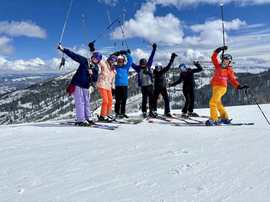 group of skiers waving poles